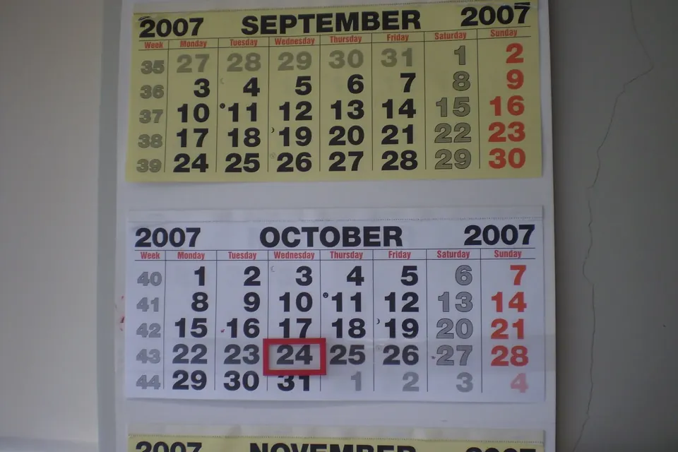 A paper wall calendar showing September and October 2007, with one day circled in red