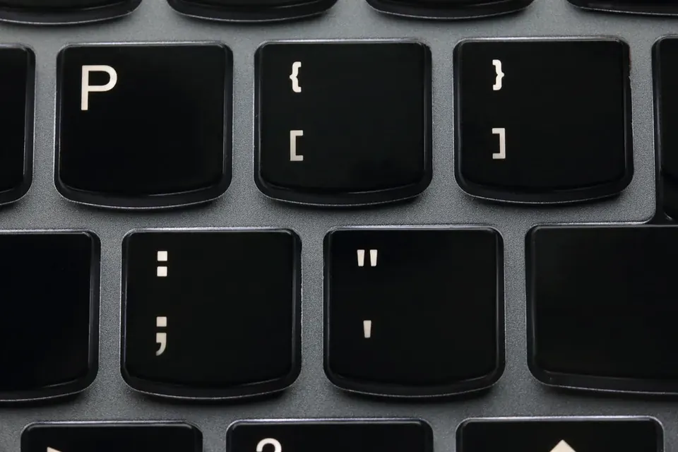 Close-up of black keyboard keys for brackets, braces, colon and quote