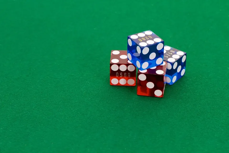 A small pile of red and blue translucent dice on green felt