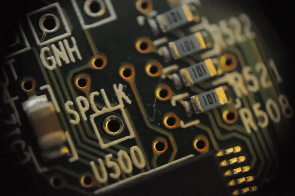 Macro view of a green circuit board with printed labels and small components