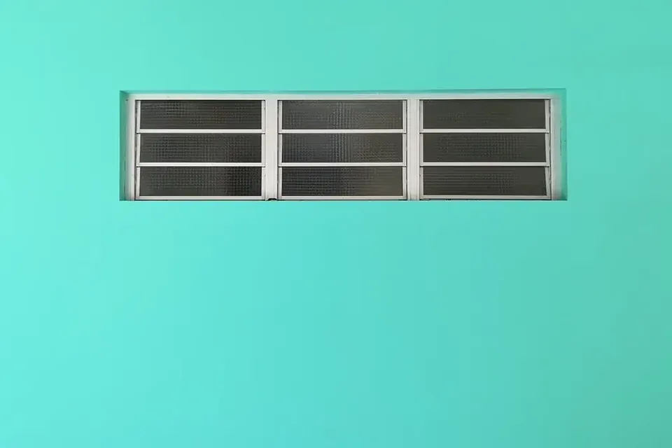 A strip of small window panes set into a turquoise wall