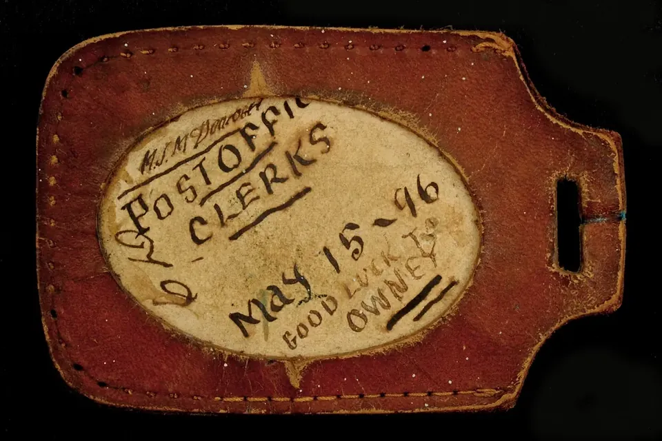 An old leather luggage tag with a handwritten date, May 15-96