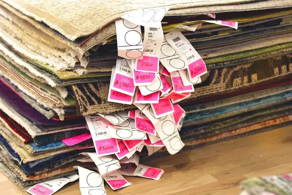Pink and white price tags spilling out of a stack of fabric samples